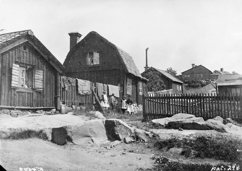 FOTOGRAFI
Vy österut. Gränd söder om Bergsprängargränd 6. Några barn står vid staketet där det hänger täcken.   1885-1905
FOTOGRAF: Salin, Kasper. 
BILDNUMMER: F 4279
Stadsmuseet i Stockholm